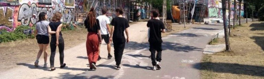 Eine Gruppe junger Menschen vor einer Graffitti- Wand